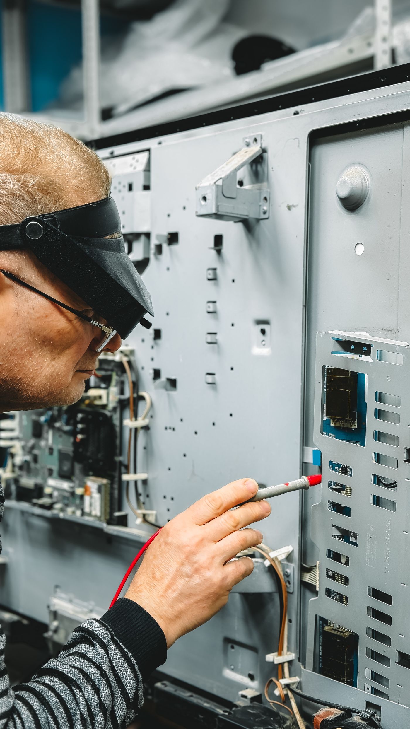Technician checking instruments in an industrial equipment rack.