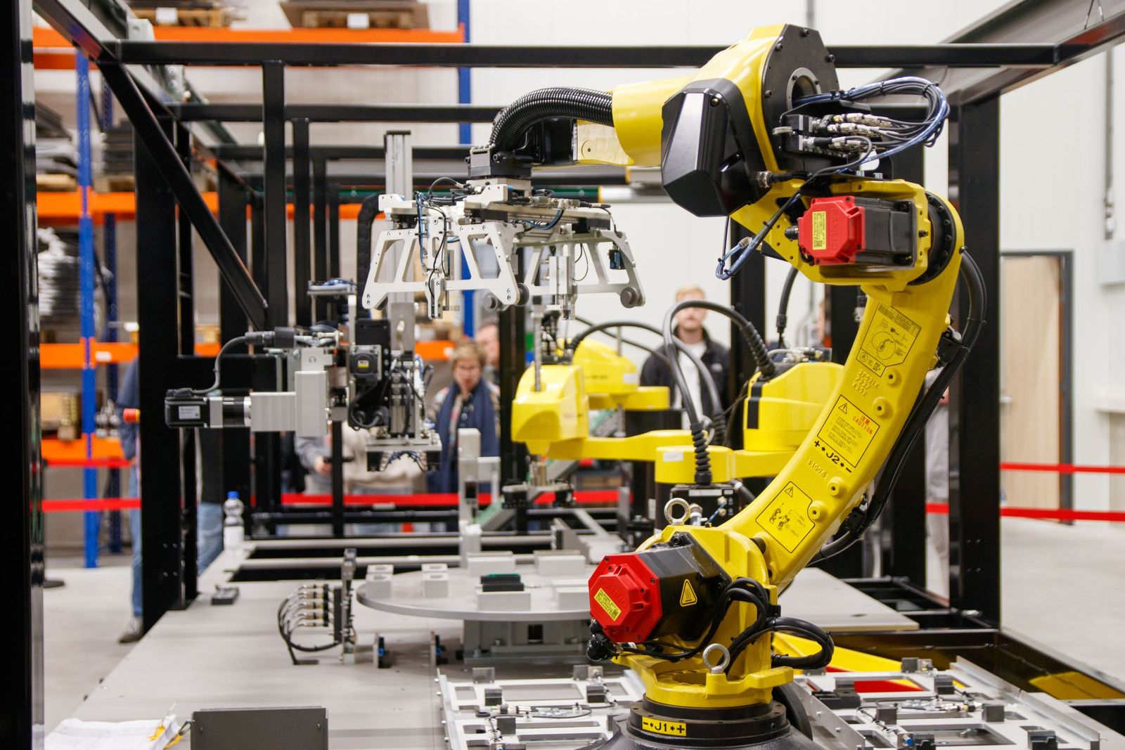 Industrial robot with gripper in an automated production cell.